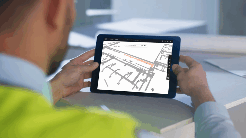 man holding Ipad with construction plans on it.